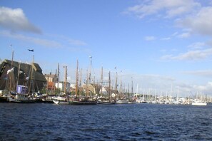 A marina with multiple sailboats docked along the waterfront, buildings in the background, and a clear sky above. - near Warnemünde (Rostock) (Admannshagen-Ausbau)