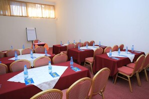 A conference room with multiple tables, each with chairs and water bottles. - Yaya Africa Athletics Village (Addis Ababa)
