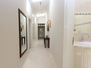 A hallway with a mirror, a door, and a sink area. - 28 Residence Bismarck (Sylt)