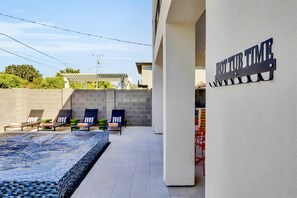 A pool area with lounge chairs and a sign reading 'HOTEL TIME'. - Modern Manor-6BR, Pool&Spa, Air Hockey, Ping Pong (Scottsdale)