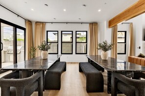 A conference room with a long table, benches, and potted plants. - Modern Manor-6BR, Pool&Spa, Air Hockey, Ping Pong (Scottsdale)
