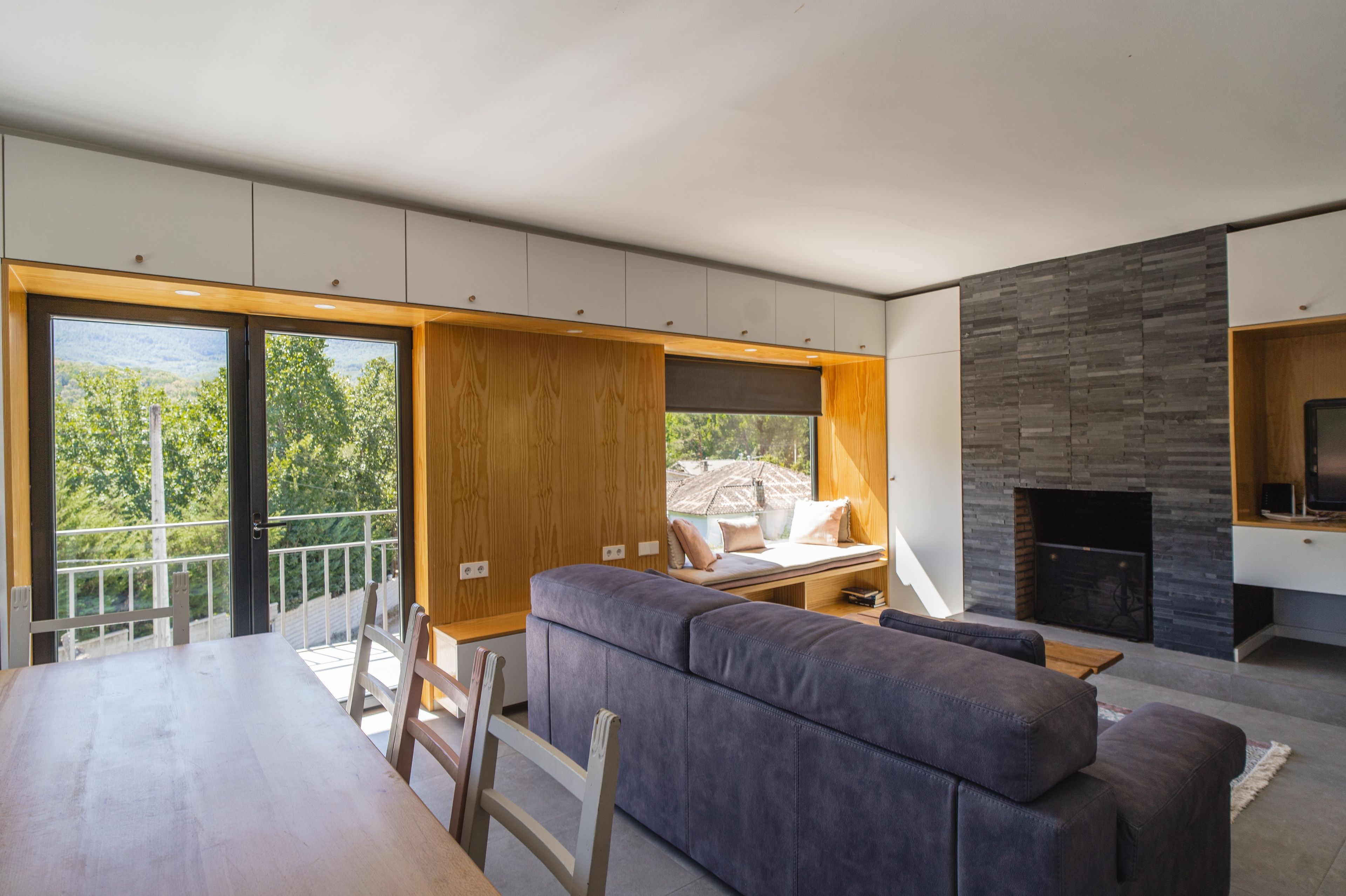 Una sala moderna con sofá, mesa de comedor y chimenea.