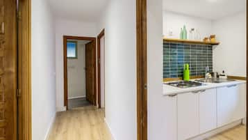 Een moderne keuken met witte kastjes, een betegelde achterwand en een roestvrijstalen spoelbak.