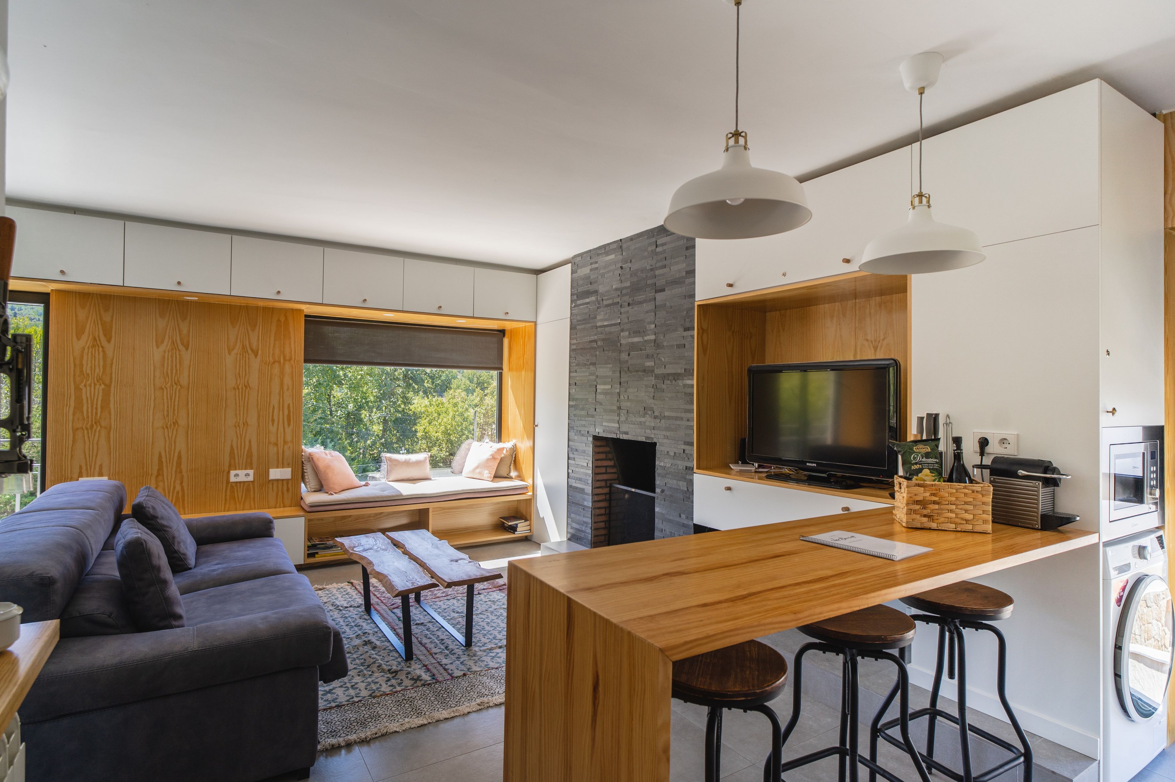 Ein stilvoller Wohnraum mit einer Couch, einem Holztisch und einem Fernseher.