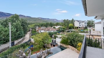 A residential area with houses, a swimming pool, and a mountain backdrop.