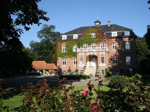 Ein großes Backsteinhaus mit einem markanten Eingang, einem Balkon und einer Fahnenstange.