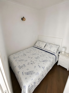 Ein Schlafzimmer mit einem Bett, einem Nachttisch und einer Wandleuchte.