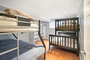 A bunk bed room with a wooden ladder and a small desk. - 2BR Suite - Close to Big White, Airport, and Downtown! (Kelowna)