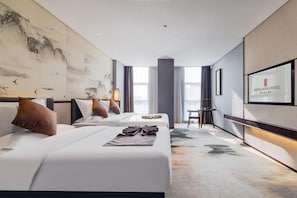 Ein Hotelzimmer mit zwei Betten, einem Schreibtisch und einem großen Gemälde an der Wand.