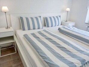 Ein Hotelzimmer mit einem Bett, zwei Nachttischen und Lampen.