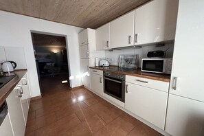A modern kitchen with white cabinets, a wooden countertop, and a microwave. - Holiday apartment in Ahaus with swimming pool (Ahaus)