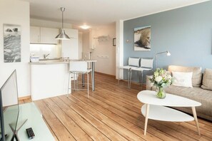 A modern living space with a kitchen, dining area, and seating area. - "Waddensee" at Uns to Hus (Juist)