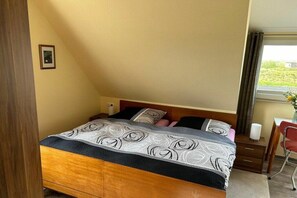 A bedroom with a bed, a desk, and a chair. - Holiday apartment in Juist with swimming pool (Juist)
