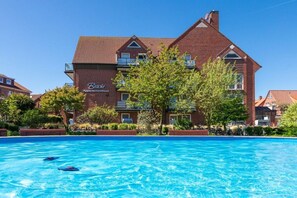 Ein Hotel mit Schwimmbad, einer Ziegel-Fassade und einem Schild, auf dem 'Bradt Apartmenthaus' steht.