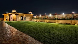 A well-lit building with a paved pathway leading to the entrance.