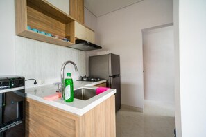 A modern kitchen with a built-in water dispenser, a stainless steel refrigerator, and wooden cabinetry. - Little Nuts Villa (Jimbaran)