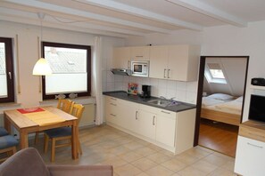 A compact kitchen with a microwave, sink, and dining area. - Guesthouse "Wangerland" for up to 4 people (Wangerland)