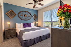 A bedroom with a bed, nightstands, a ceiling fan, decorative wall art, and a window with blinds. - Scottsdale Retreat Near Old Town & Fashion Square (Scottsdale)