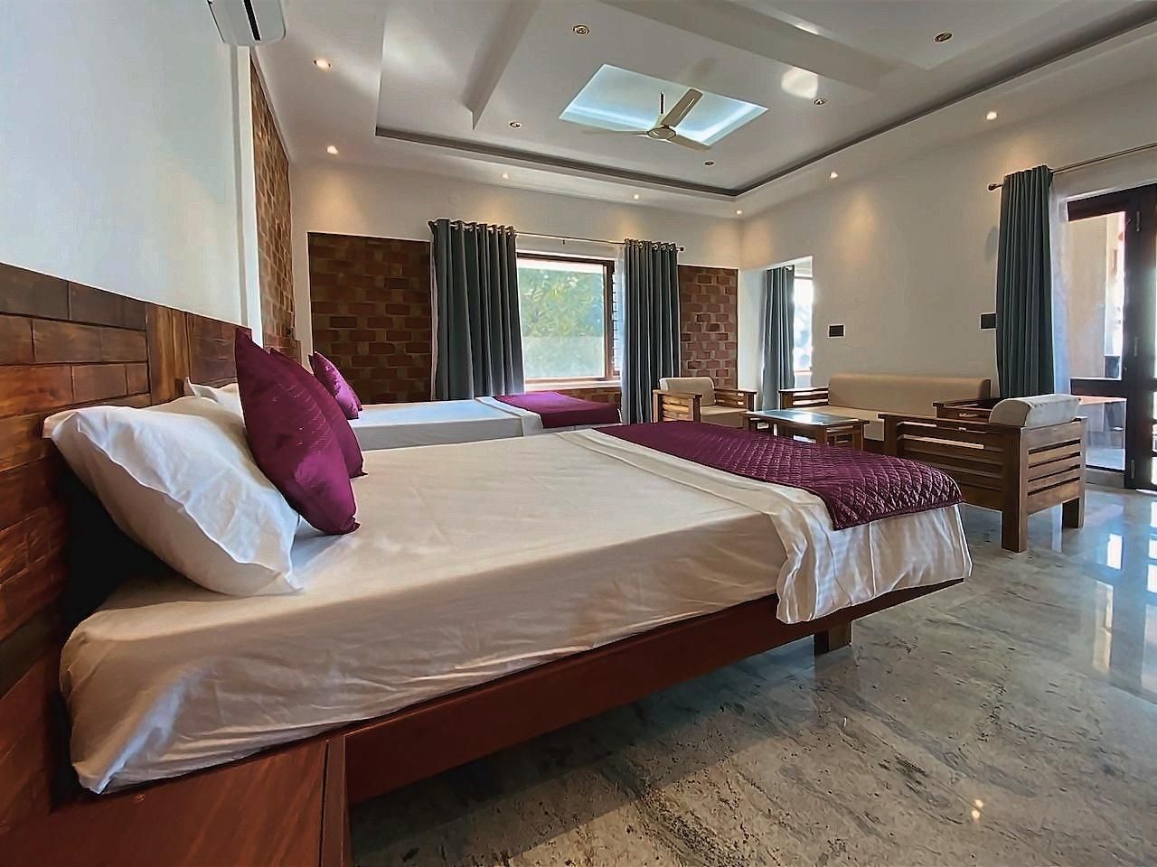 A hotel room with a large bed, a desk, and a chair.