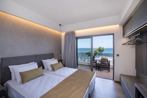 Un cuarto de hotel con una cama, un escritorio y vista al mar.