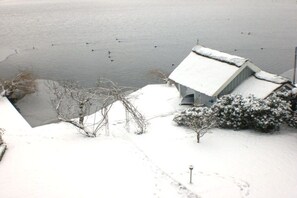 A snow-covered landscape with a house and a body of water. - Angelika von Lingelsheim (Ratzeburg)