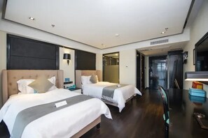 Een hotelkamer met twee bedden, een bureau en een spiegel.