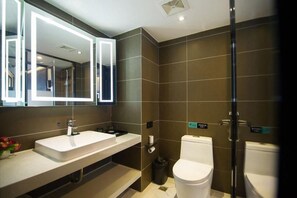 Een moderne badkamer met een grote spiegel, een wastafel, een toilet en een douchehoek.