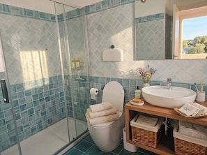A bathroom with a glass shower enclosure, a toilet, a sink with a basin, and a mirror above the sink. - Click Sardegna Villa SeaSky – Sea View with Garde (Alghero)