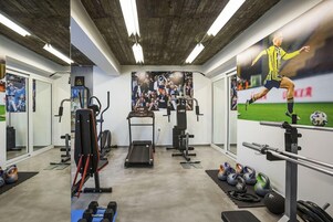 Un gimnasio con cintas de correr, máquinas de pesas y pesas rusas.