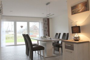 Een moderne eethoek met een tafel, stoelen en een lamp.
