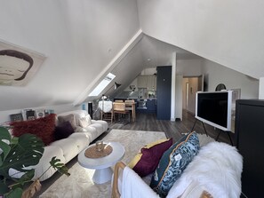 A modern loft apartment with a dining area, kitchen, and living space. - Bright Top Floor Flat with Balcony in Purley (London)