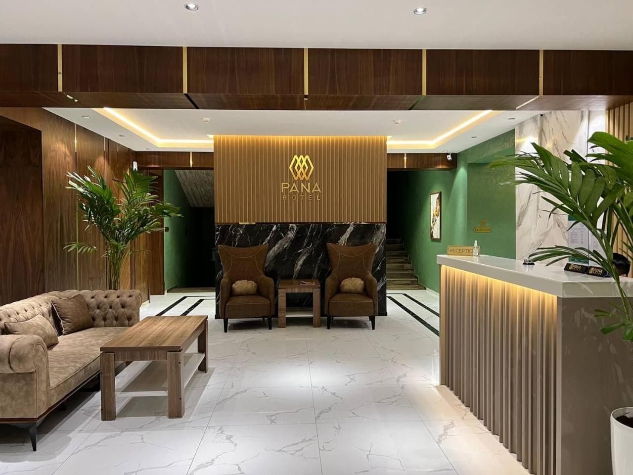 A hotel reception area with a reception desk, two armchairs, a sofa, and a coffee table.