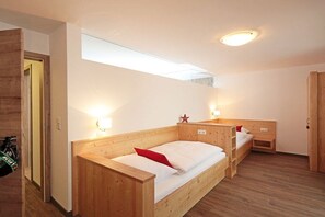 A room with a wooden bunk bed, a small desk, a bicycle, and a window with a view. - Holiday apartment in Mittelberg with Wi-Fi (Mittelberg)