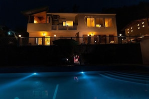 A two-story building with a swimming pool in the foreground.