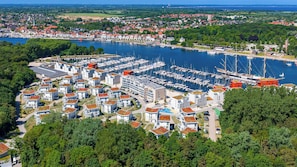 Un port de plaisance où sont amarrés des bateaux, entouré d’immeubles résidentiels aux toits rouges.