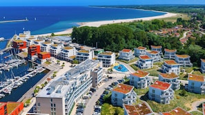 Una zona residencial costera con edificios modernos, un puerto deportivo y una playa.