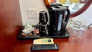 A coffee maker, a remote control, and some cups on a tray. - Hotel Blackpool (Blackpool)