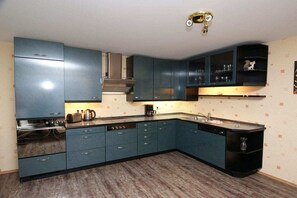 A kitchen with blue cabinets, a stove, and a dishwasher. - Holiday apartment with 2 bedrooms (Born \/ Darss)