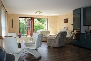 A living room with a dining area, a sofa, and a television. - Holiday apartment with 2 bedrooms (Born \/ Darss)