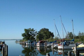 A marina with boats docked at wooden piers, calm water, and trees in the background. - Holiday apartment with 2 bedrooms (Born \/ Darss)