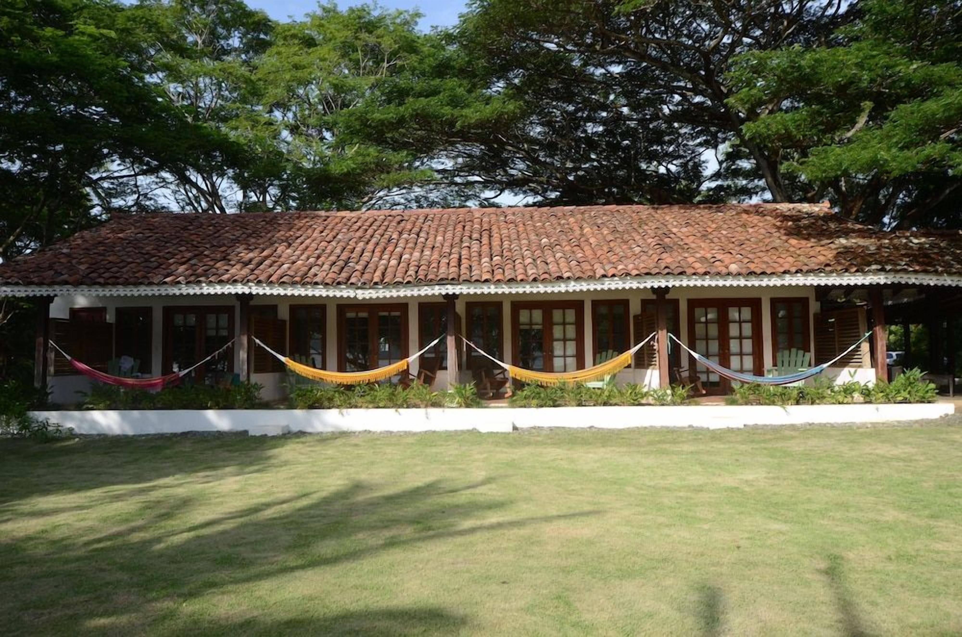 A building with a tiled roof and a covered porch with a white railing.