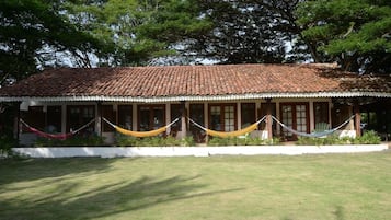 A building with a tiled roof and a covered porch with a white railing.