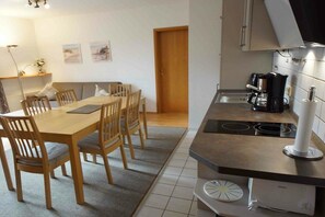Eine kompakte Küche mit Essbereich, einer Kaffeemaschine und einem Einbauofen.
