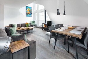 Ein moderner Loft-Wohnraum mit Essbereich, Schlafgalerie und Kamin.