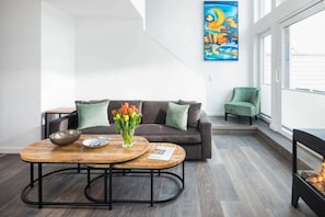 Ein modernes Wohnzimmer mit einer Couch, einem Couchtisch und einem Gemälde an der Wand.