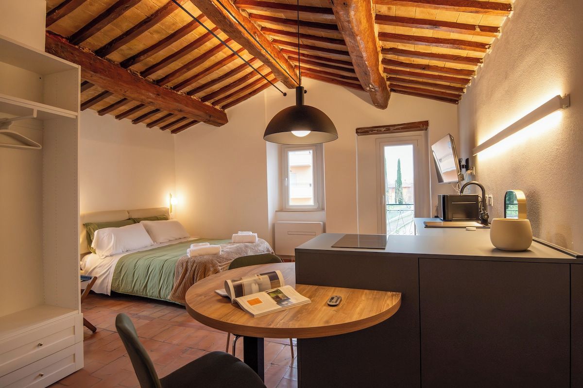 A compact bedroom with a bed, bedside table, and a window.