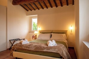 A bedroom with a bed, two bedside lamps, a window, and a wooden ceiling. - Chic Design Condo with Fast WiFi Near Assisi (Rivotorto)