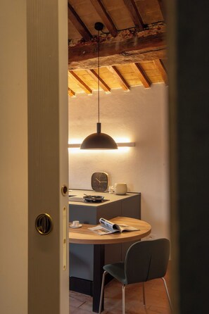 Un coin repas accueillant avec une table ronde, une chaise, une horloge murale et une suspension.