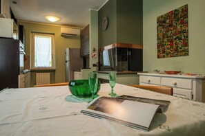 A dining area with a table set for two, a green bowl, and two glasses. - Garden Retreat Apt w/ Parking, Near Perugia Center (Perugia)