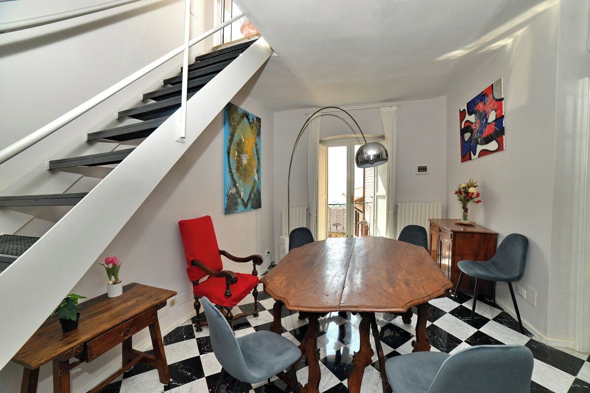 A dining area with a checkered floor, a wooden table, and chairs.